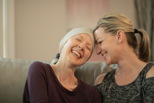 An Elderly Oncology Patient Shares a Laugh with Her Daughter stock photo